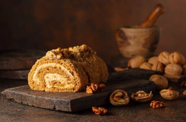 Kahverengi arka planda cevizli tatlı. Kahverengi şeker, ceviz ve kremalı kek..