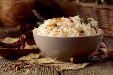 Eski ahşap bir masada baharatlı geleneksel Alman lahana turşusu..