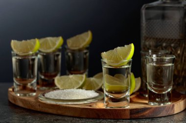 Siyah arka planda tuz ve limon dilimli altın tekila. Boşluğu kopyala.