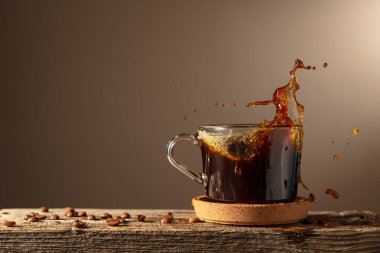 Kahverengi arka planda cam bardakta sade kahve. Boşluğu kopyala.