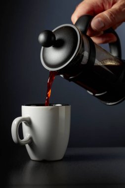 Siyah bir masada kahve fincanına Fransız kahvesi dökmek..