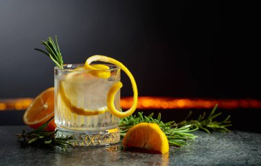 Siyah arka planda limon ve biberiyeli cin tonik kokteyli. Boşluğu kopyala.