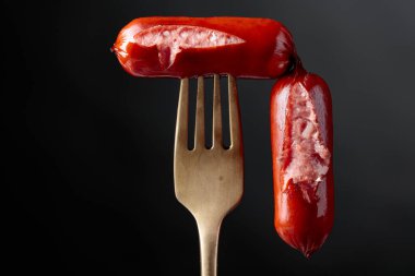 Bir çatal üzerinde ızgara sosis. Siyah arka plan, kopya alanı. 