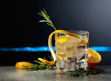 Siyah arka planda limon ve biberiyeli cin tonik kokteyli. Boşluğu kopyala.