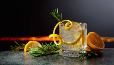 Siyah arka planda limon ve biberiyeli cin tonik kokteyli. Boşluğu kopyala.