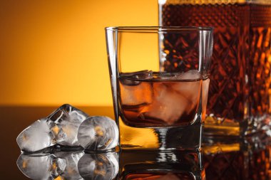 Siyah yansıtıcı arka planda buzlu viski..