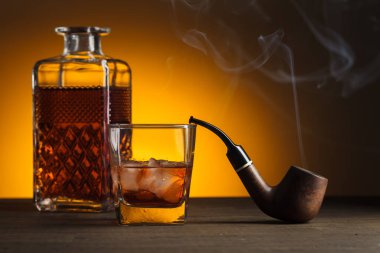 Viski ve pipo eski ahşap bir masada. Boşluğu kopyala