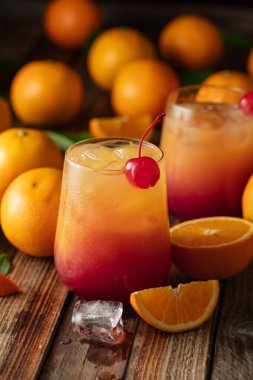 Klasik tekila gündoğumu kokteyli, portakal suyu ve nar şurubunun katmanlı renkleri, bir şişe maraska şişi ile süslenmiş..