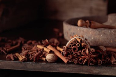 Eski ahşap bir masada tarçın çubukları, anason ve hindistan cevizi. Boşluğu kopyala.