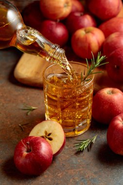 Elma şarabı şişeden bardağa dökülür. Eski bir mutfak masasında elmalı taze içecek..
