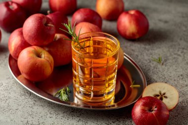 Elma suyu ve taze elmalar eski bir mutfak masasında..