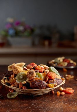 Kahverengi mutfak masasında kurutulmuş tropik meyve, fındık ve kuru üzüm. Boşluğu kopyala.