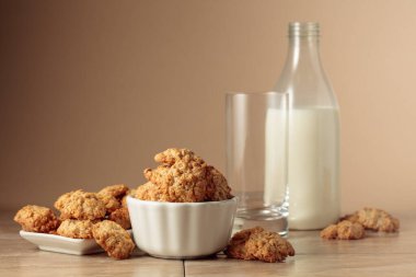 Yulaf ezmeli kurabiye ve süt mutfak masasında. Kopyalama alanı olan bej arkaplan.