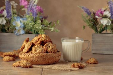Mutfak masasında yulaflı kurabiye ve süt. Kopyalama alanı olan bej arkaplan.