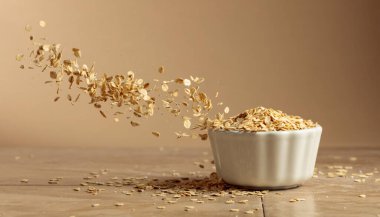 Bej arka planda hareket eden yulaf gevrekleri. Boşluğu kopyala.