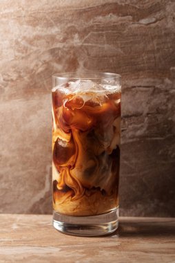 Kremalı buzlu kahve, ferahlatıcı ve tatlı kahve bej seramik bir masada..