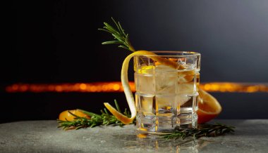 Siyah arka planda limon ve biberiyeli cin tonik kokteyli. Boşluğu kopyala.