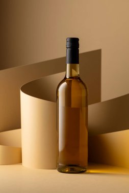 Bottle of white wine on a beige background. Copy space.