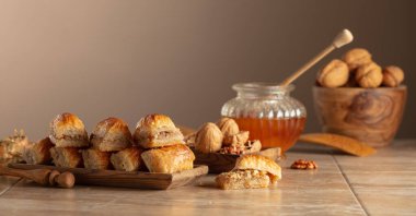 Bej arka planda ceviz ve bal olan baklava. Geleneksel Doğu Çölü ahşap tabakta. Boşluğu kopyala.