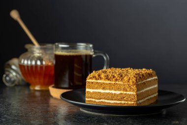 Geleneksel ballı kek ve siyah arka planda sade kahve. Boşluğu kopyala.