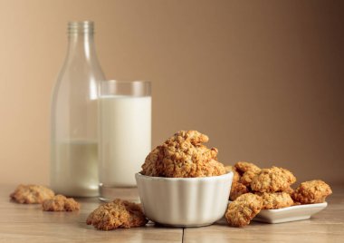 Yulaf ezmeli kurabiye ve süt mutfak masasında. Kopyalama alanı olan bej arkaplan.