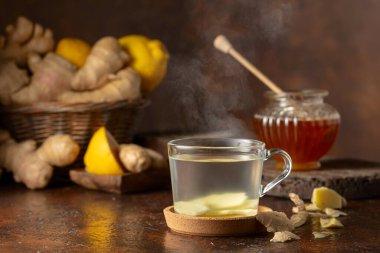Kahverengi arka planda limonlu ve ballı zencefil çayı.