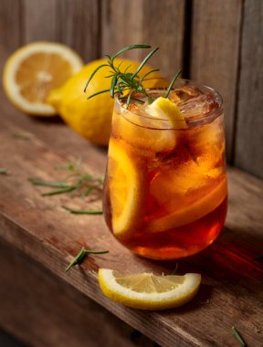 Buzlu çay ya da eski ahşap bir masada buzlu, biberiyeli ve limon dilimli alkollü kokteyl. Taze, sağlıklı, soğuk limon suyu. Buzlu ve limonlu çay..