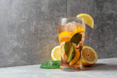 Buzlu, naneli ve limonlu sert maden suyu. Gri arka planda malzemeleri olan soğuk, ferahlatıcı bir içecek. Boşluğu kopyala.