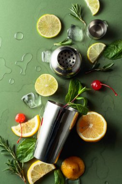 Kokteyl yapmak için malzemelerle karıştırıcı. Yeşil arka plan. Üst görünüm.