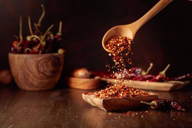 Biberler ahşap bir tabağa dökülür. Eski ahşap bir masada kırmızı biber ve kırmızı biber..