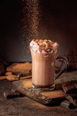 Kakao tozu serpiştirilmiş kremalı sıcak çikolata içeceği. Bir kupa sıcak çikolata, kırık çikolata ve kakao tozu. Boşluğu kopyala.