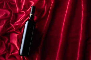 Bottle of red wine on a satin background. Top view.