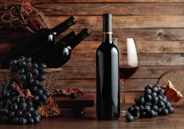 Red wine and blue grapes. Wine and grapes in a vintage setting on an old wooden table.