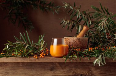 Eski ahşap bir masada taze böğürtlenli bir bardak deniz dikenli meyve suyu. Sağlıklı bir vitamin içeceği. 