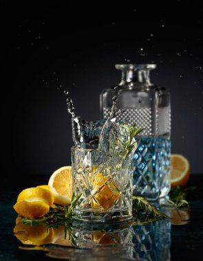 Limon ve biberiyeli cin tonik kokteyli. Limon dilimi bardağa dökülür Kokteylle.