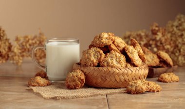 Mutfak masasında yulaflı kurabiye ve süt. Kopyalama alanı olan bej arkaplan.