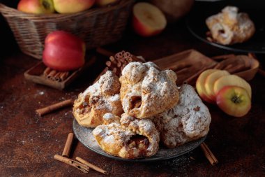 Elma ve tarçınlı ev yapımı mini elmalı turtalar. Üzerine pudra şekeri serpiştirilmiş taze pişmiş yiyecekler. Viyana pastası.