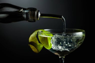 Votka ya da cin buzlu bir bardağa doldurulur. Koyu arkaplanda limon kabuğu olan kokteyl..