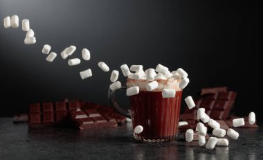 Cam bardakta mini marşmelovlu sıcak çikolata. Kırık bir arka planda acı çikolata.