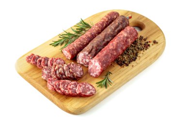 Kesme tahtasında dilimlenmiş füme sosis. Beyaz arka planda izole edilmiş biberiyeli ve baharatlı sosisler..