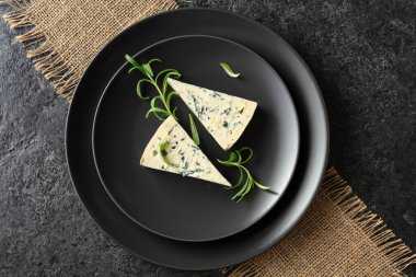 Siyah tabakta mavi peynir ve biberiye. Üst Manzara. Boşluğu kopyala.