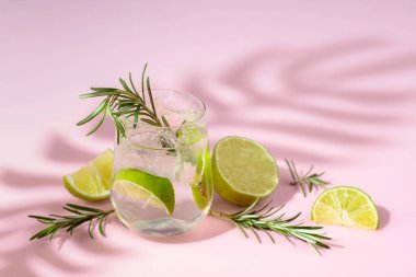 Buzlu, limonlu ve biberiyeli yaz ferahlatıcı içecek. Kopyalamak için pembe arkaplan.