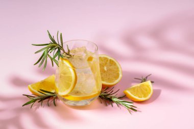 Buzlu, limonlu ve biberiyeli yaz ferahlatıcı içecek. Kopya alanı ile pembe arkaplan.