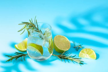 Buzlu, limonlu ve biberiyeli yaz ferahlatıcı içecek. Kopyalama alanı olan mavi arkaplan.