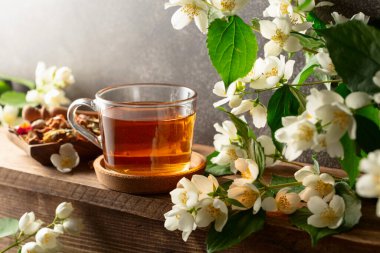 Yasemin çayı ve taze yasemin çiçekleri ahşap bir masada..