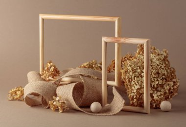 Ahşap çerçeveler, çuval bezi kurdelesi ve bej arka planda kurumuş ortanca çiçekleri. Doğal organik ürün, marka kimliği ve ambalaj için arka plan. Boşluğu kopyala.