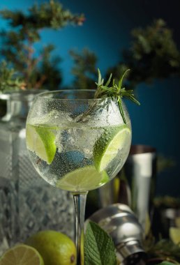 Buzlu kokteyl cin tonik ve lacivert arka planda ıslak bardakta limon dilimleri. Boşluğu kopyala.