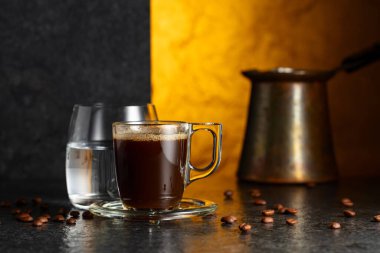 Siyah taş bir masada espresso ve bir bardak soğuk su. Boşluğu kopyala.