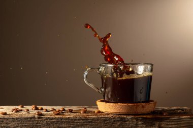 Kahverengi arka planda cam bardakta sade kahve. Boşluğu kopyala.