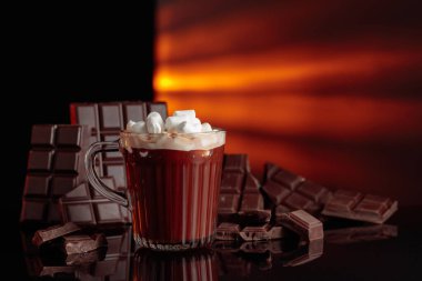 Cam bardakta mini marşmelovlu sıcak çikolata. Kırık bir arka planda acı çikolata.